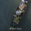 Local vendor selling fresh produce on a rowing boat at Tha Kha floating market