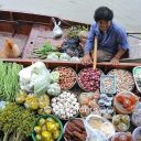 A shopper stops by to chat with the vendor at Tha Kha floating market